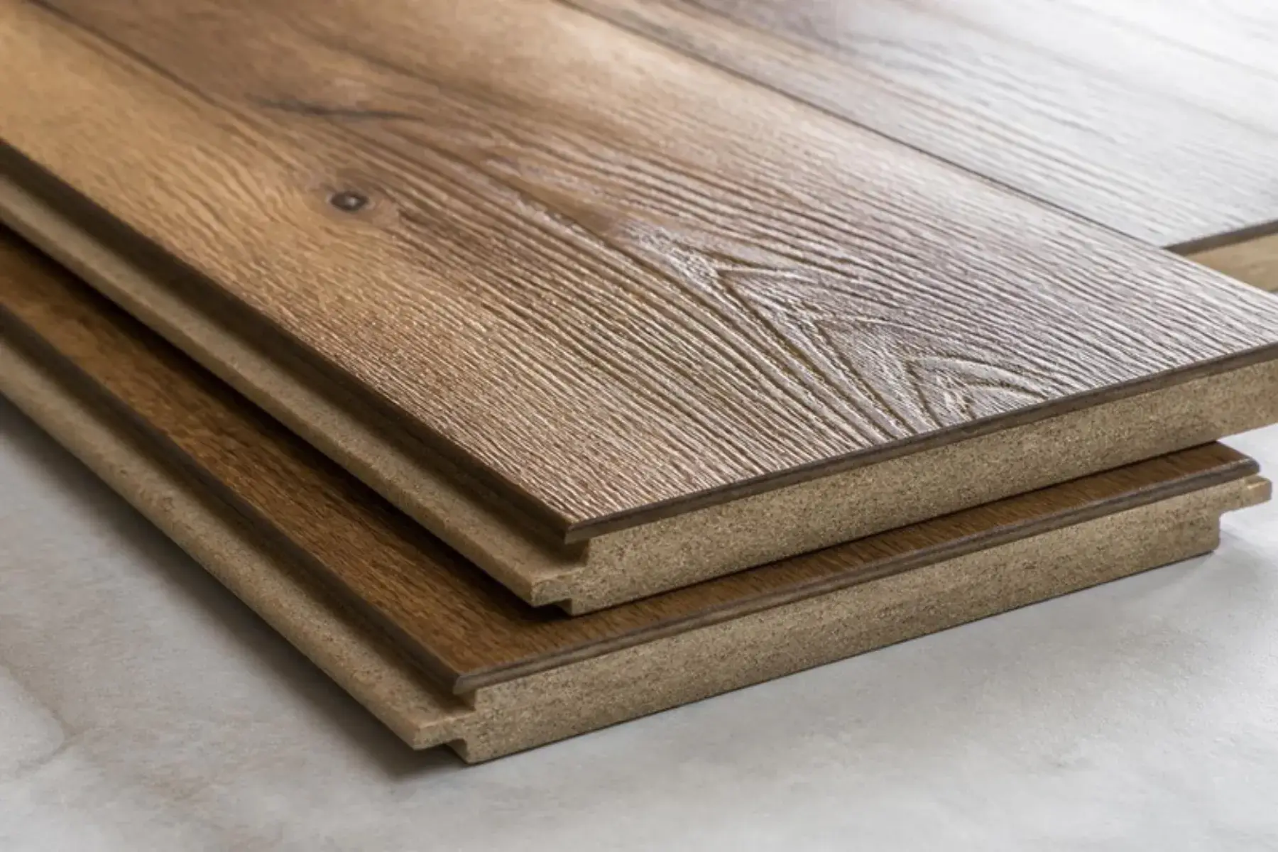 Thick AC4-rated laminate planks in a hickory look showing deep embossed texture and click-lock edges