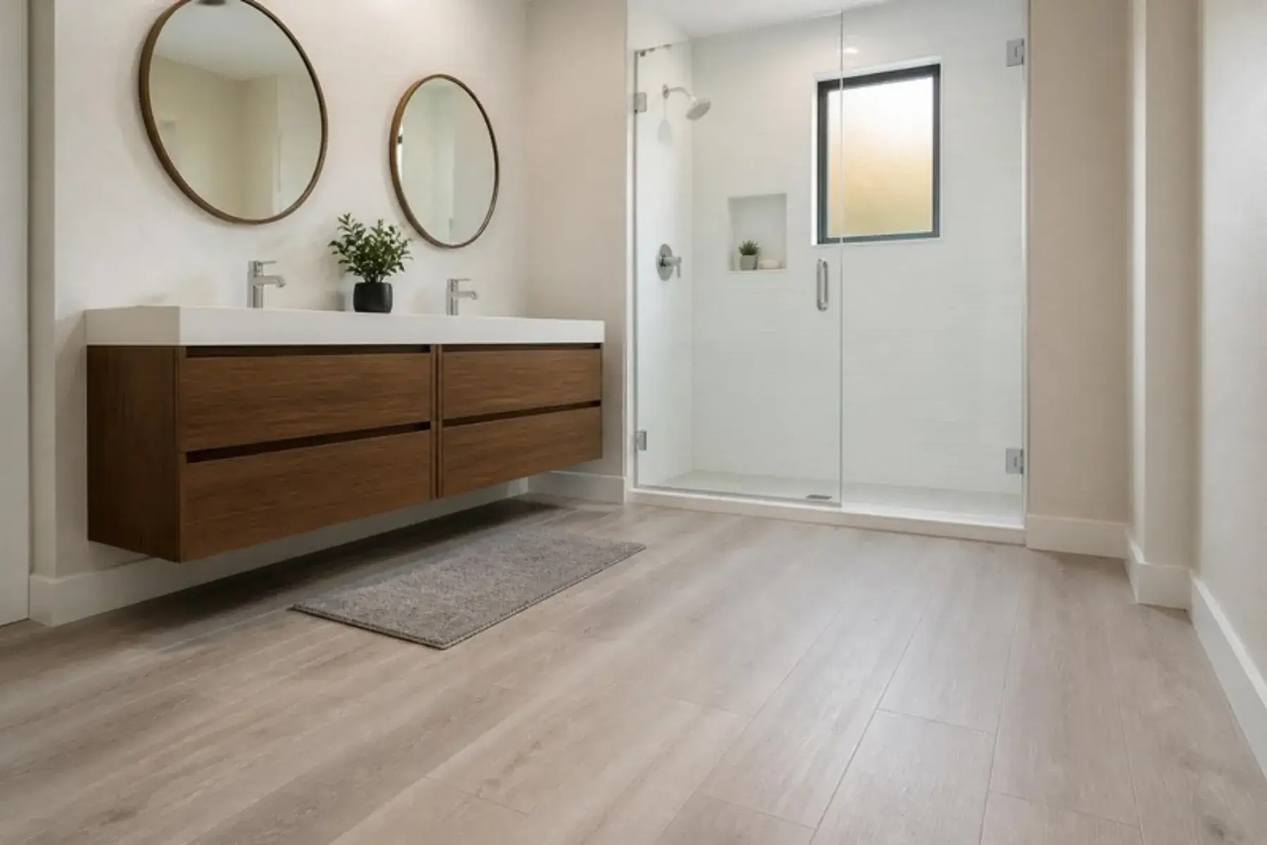 Bathroom with grey-washed laminate plank flooring, floating walnut vanity and glass shower (illustrative scene)