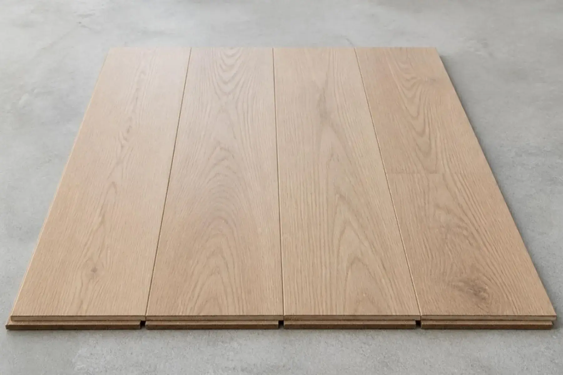 Premium wide laminate planks in a natural European oak look, laid flat to show the thick HDF core and click-lock ends