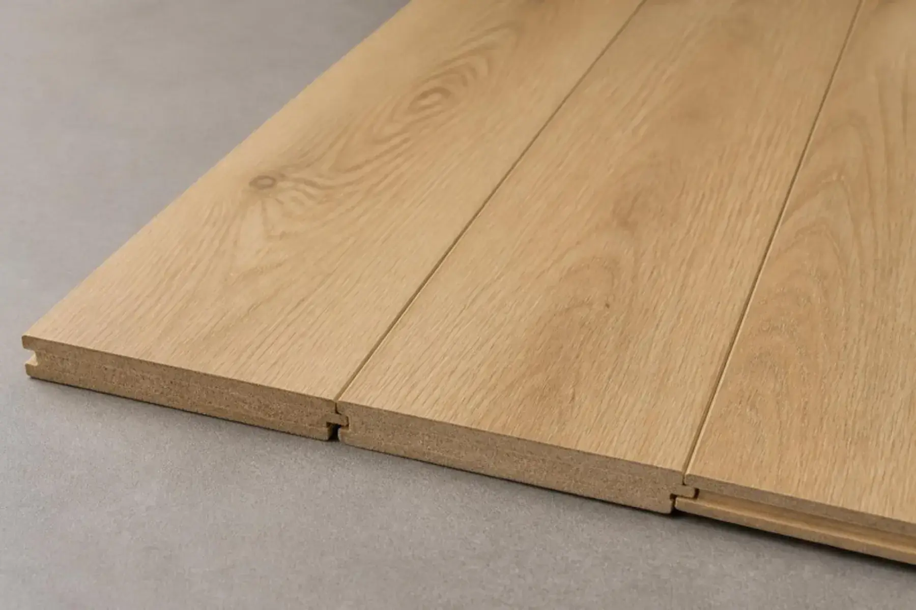 Standard laminate planks in a light natural oak look with square edges and click-lock profiles